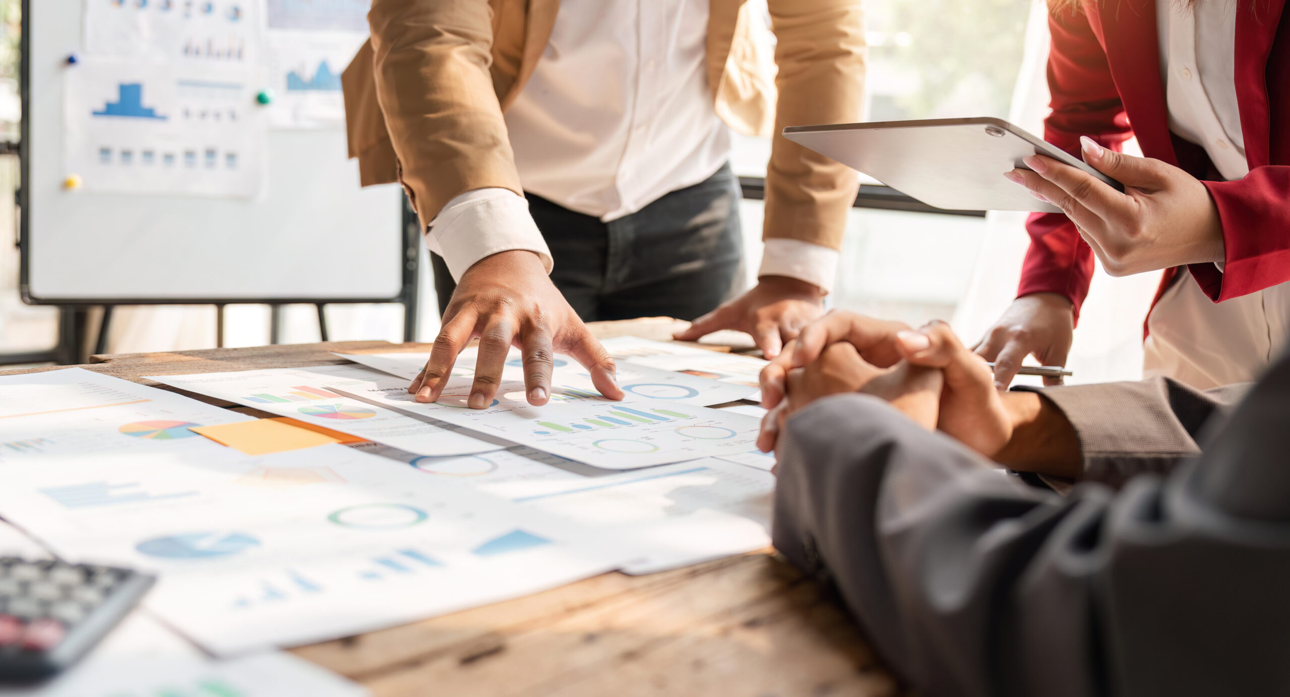 Ein Team diskutiert Diagramme und Datenanalysen bei einer Besprechung an einem Tisch.